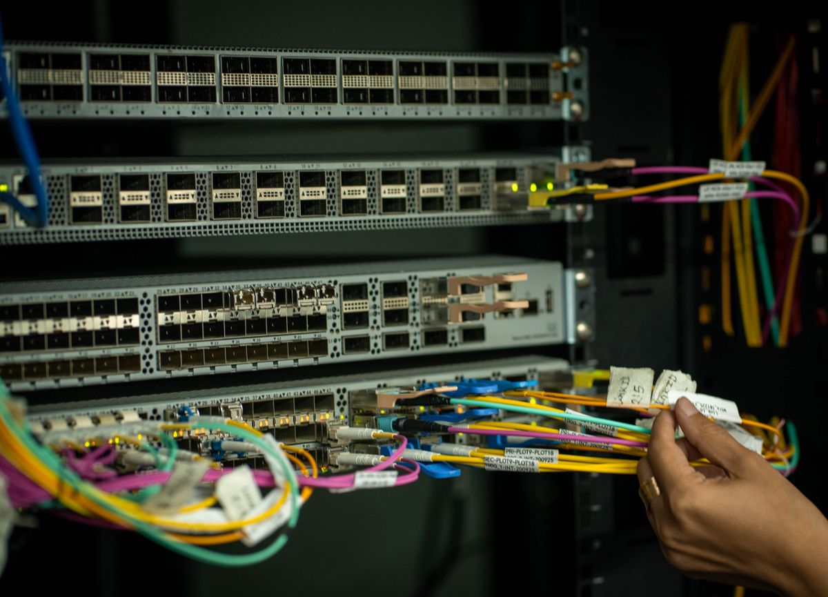 Technician managing fiber optic cables in a server room